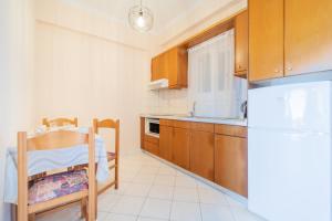 a small kitchen with a table and a refrigerator at Lido Sofia Apartments in Agios Gordios