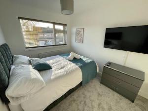 um quarto com uma cama grande e uma televisão de ecrã plano em St Blaise em Water Orton