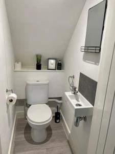 uma casa de banho branca com um WC e um lavatório em St Blaise em Water Orton