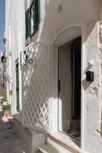 een wit gebouw met een deur en een raam bij Cà Giò in Ostuni