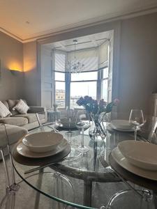 a living room with a glass table with wine glasses at Lan Y Môr 4 Aberystwyth in Aberystwyth