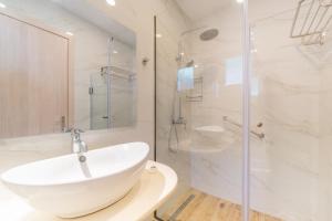 a bathroom with a white sink and a shower at Lido Sofia Apartments in Agios Gordios