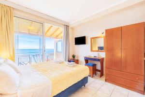 a bedroom with a bed and a view of the ocean at Lido Sofia Apartments in Agios Gordios