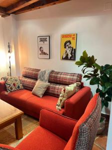 a living room with a red couch and a plant at Rascacielos San Martín in Cuenca