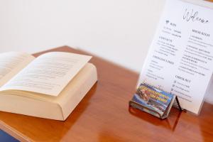 an open book sitting on a table next to a bookiazepinyl at Lido Sofia Apartments in Agios Gordios