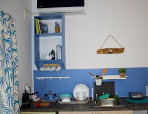 a kitchen with a sink and a blue wall at Gabari Studio in Boúkka