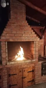 a brick fireplace with a fire in it at Casa Ceteras in Cavnic