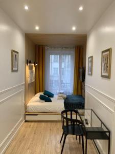 um pequeno quarto com uma cama e uma mesa de vidro em 80 - Paris Cinema Sebastopol em Paris