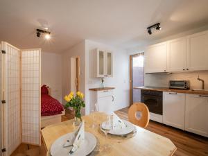 kuchnia i jadalnia ze stołem oraz pokój z łóżkiem w obiekcie Latina II w mieście Westendorf