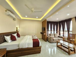 a bedroom with a bed and a couch and a table at Navarathna Comforts in Madikeri