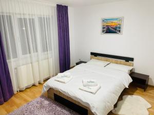 a bedroom with a bed with two towels on it at Casa Ceteras in Cavnic