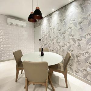 Un comedor con una mesa y sillas blancas. en Apartamento no Boqueirão, Perto Praia com Piscina, en Praia Grande 18 fotos más