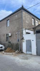 een gebouw met een garage en een ernaast geparkeerde auto bij Resulzade Villa in Baku