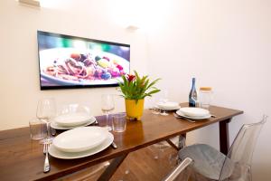 mesa de comedor con platos y vasos y TV en tHE Keith Haring Home en Milán