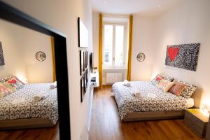 Habitación pequeña con 2 camas y ventana en tHE Keith Haring Home en Milán
