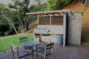 einen Grill auf einer Terrasse mit Stühlen und einem Tisch in der Unterkunft Casa Mon Coeur-Playa Del Coco Ocean View in Coco