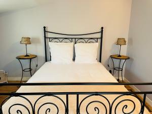 - une chambre avec un lit et deux lampes de chaque côté dans l'établissement Petite Maison des Renaudins, à Taillebourg