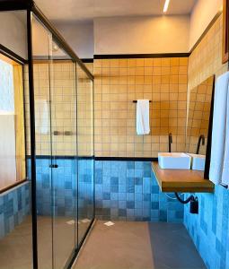 uma casa de banho com uma cabina de duche em vidro e um lavatório. em Resort Tororomba em Olivença