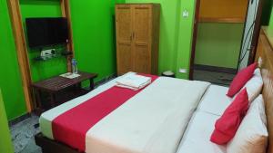 a bedroom with a bed and a green wall at SM Residency in Coimbatore