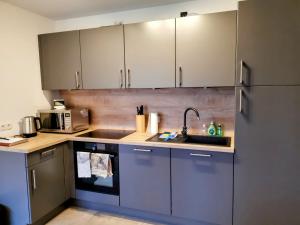 a kitchen with a sink and a refrigerator at Neubauferienwohnung Ankerplatz in Stein