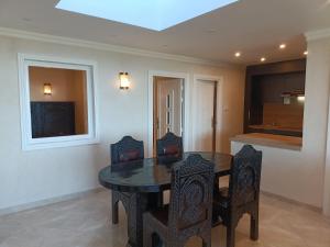 エッサウィラにあるAppartement golf Mogadorのテーブルと椅子とテレビのあるダイニングルーム +8枚の写真