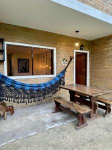 a bench and a hammock outside of a building at EcoFlat Moderno e Aconchegante in Bonito