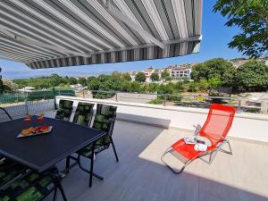 a patio with a table and chairs on a balcony at Luxury apartment ANI II with jacuzzi in Sutivan