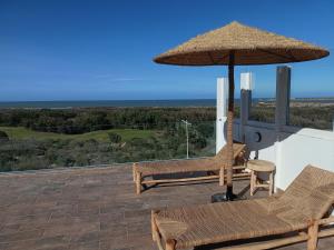un patio con due sedie e un ombrellone di Appartement golf Mogador a Essaouira