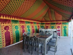 tavolo e sedie in una stanza con una parete colorata di Appartement golf Mogador a Essaouira