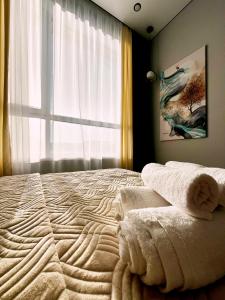 a bedroom with a bed with towels on it at Двухкомнатная квартира на Левом Берегу in Taldykolʼ