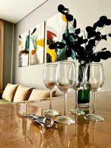 a table with three wine glasses and a vase with flowers at Двухкомнатная квартира на Левом Берегу in Taldykolʼ