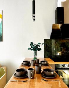 a table with four black bowls and a vase with flowers at Двухкомнатная квартира на Левом Берегу in Taldykolʼ