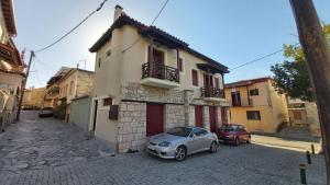 Arachova center - traditional residence في أراخوفا: سيارة صغيرة متوقفة أمام مبنى