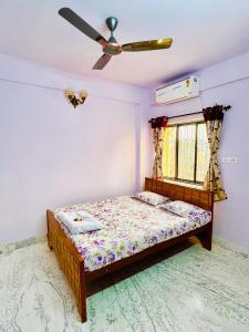 een slaapkamer met een bed en een plafondventilator bij Park View Spacious Apartment with Hall , AC and Kitchen in kolkata