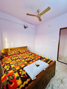 een slaapkamer met een bed met een dekbed en een plafondventilator bij Park View Spacious Apartment with Hall , AC and Kitchen in kolkata