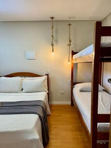 two beds in a room with two bunk beds at EcoFlat Moderno e Aconchegante in Bonito