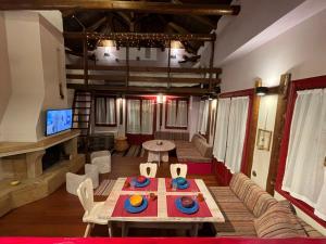 Arachova center - traditional residence في أراخوفا: غرفة معيشة مع طاولة وكراسي وأريكة +13 صورة
