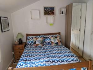 a bedroom with a bed with a blue and white comforter at Central and peaceful room with your own bathroom in London