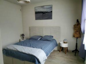 a bedroom with a bed and a picture on the wall at Charmante maison, 40mn de Paris in Triel-sur-Seine