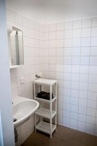 ein weißes Badezimmer mit einem Waschbecken und einem Spiegel in der Unterkunft Quiet Apartment - Vienna in Wien