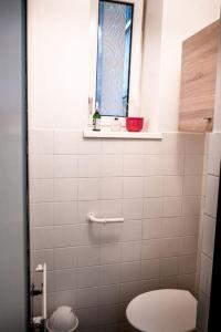 ein Bad mit einem WC und einem Fenster in der Unterkunft Quiet Apartment - Vienna in Wien