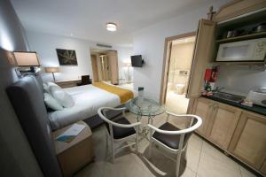 a hotel room with a bed and a glass table at Solana Hotel & Spa in Mellieħa