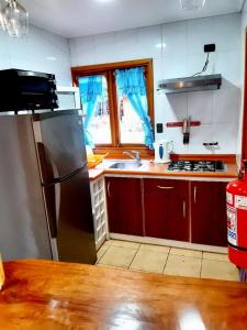 a kitchen with a stainless steel refrigerator and a sink at Mapulauquen Cabañas in Pucará