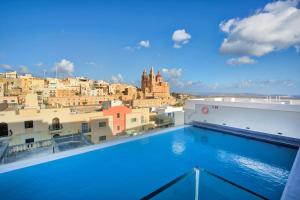 a view of a city from a swimming pool on a building at Pergola Hotel & Spa in Mellieħa +37 photos