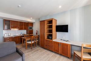 a kitchen and dining room with a couch and a table at Pergola Hotel & Spa in Mellieħa