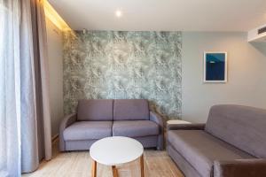 a living room with a couch and a table at Pergola Hotel & Spa in Mellieħa
