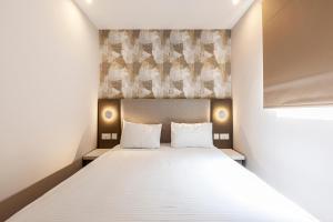 a bedroom with a large bed with two pillows at Pergola Hotel & Spa in Mellieħa