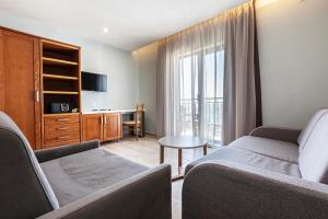 a living room with two couches and a table at Pergola Hotel & Spa in Mellieħa