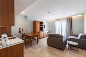 a kitchen and living room with a couch and a table at Pergola Hotel & Spa in Mellieħa