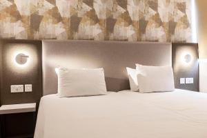 a bedroom with a bed with two pillows at Pergola Hotel & Spa in Mellieħa